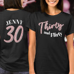 30. Geburtstag dreißig koketter rosa silberner Gli T-Shirt<br><div class="desc">30 und kokett, 30. Geburtstag Glitzer Stil Effekt dreißig Skripttext in Rose Rosa und Silber Farbton mit Text auf dunklem T - Shirt und eine Zahl 30 und Ihr Name auf der Rückseite. Personalisieren Sie dieses Shirt zum 30. Geburtstag mit Ihrer Nachricht. Weitere Jahre und passende Artikel sind verfügbar. ©...</div>
