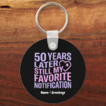 50 Years Later Still My Favorite Notification  Schlüsselanhänger<br><div class="desc">Celebrate five decades of connection with this modern, tech-inspired design. Featuring bold, vibrant typography in soft lavender and blush pink, this high-contrast graphic perfectly captures the enduring bond of a 50th anniversary. A sleek, minimalist heart and notification bell icon add a contemporary touch to a classic milestone. Ideal for anniversaries,...</div>