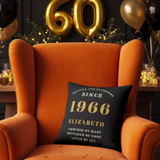 60th Birthday Gift Personalized 1966 Black Gold Kissen (A personalized black pillow on a vibrant orange velvet wingback armchair )