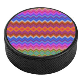 A colorful hockey puck features a vibrant zigzag 
