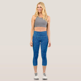 A woman's torso and legs in blue capri leggings 