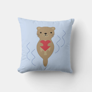 Adorable Otter umarmt ein Herz Kissen