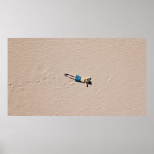 Aerial photograph of man lying on sand poster