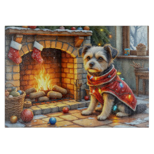 Affenpinscher sitzt vor dem Kamin mit Weihnachtsbe Schneidebrett