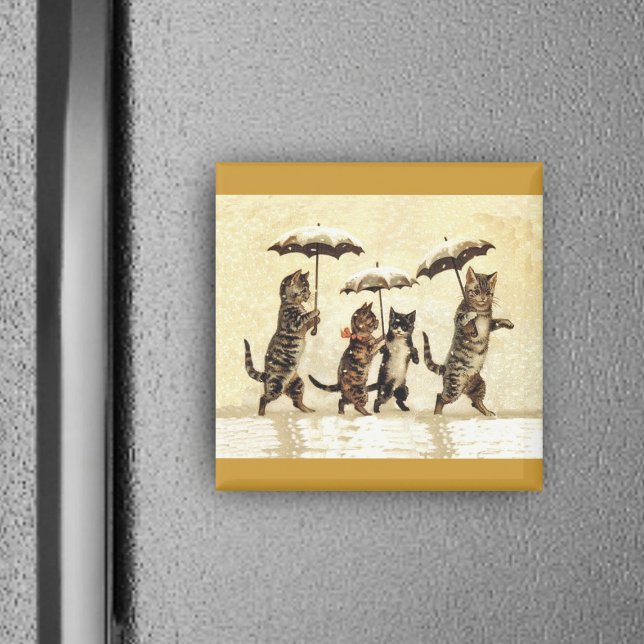 Aimant Famille de chats avec parapluies marchant dans la  (Four brown cats walking upright in snow with umbrellas on yellow square magnet.)