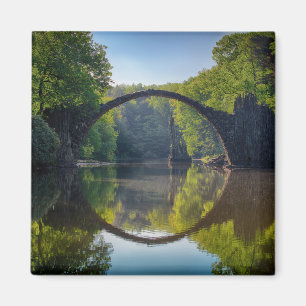 Aimant Pont rond de rock gris sur une rivière dans la fo