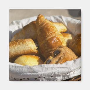 Aimant Un panier petit-déjeuner en osier avec croissants