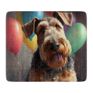 Airedale-Hund mit Kuchen und Luftballons Schneidebrett