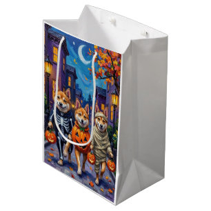 Akita-Hunde beim Trick-or-Treat in Halloween-Kostü Mittlere Geschenktüte
