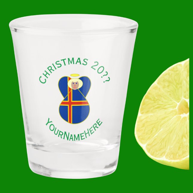 Ålander Angel Weihnachtsfahne Personalisiert Schnapsglas (Christmas angel wears the Åland Islands Flag. Green text for holiday, year, and name.)