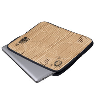 Alte schädigende Brown-Pappe mit Briefmarken und Laptopschutzhülle