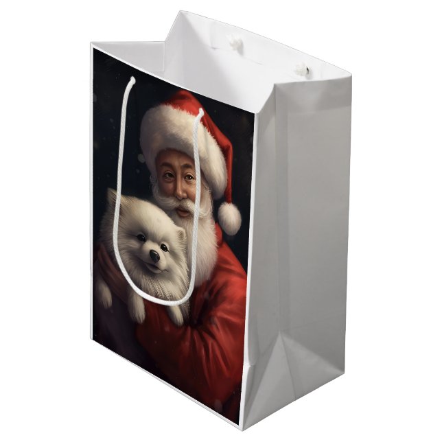 American Eskimo mit Weihnachtsmann Weihnachten Mittlere Geschenktüte (Vorderseite Schrägansicht)
