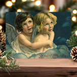Angels Vintage frohe Weihnachten<br><div class="desc">Schöne Weihnachtsfeier Angel Kinder Postkarte. "Frohe Weihnachten" Gruß in der unteren rechten Ecke geschrieben. In diesem Design befinden sich zwei wunderschöne Kinder mit Engelsflügeln, die in einer liebevollen Umarmung in den Wolken sitzen.</div>