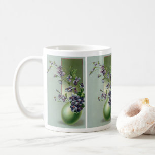 Antike blühende violette Blumen in einem Osterei Kaffeetasse