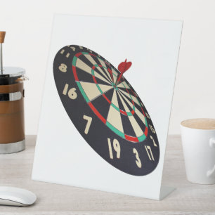 Auf dem Ziel: Der Dartpfeil hat die Dartscheibe in Sockelschild