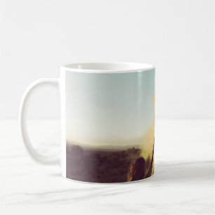 Auf der Wüste stehende Frau mit einer Flamme Kaffeetasse