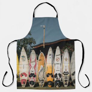 Auf offenem Feld stehen verschiedene Surfbretter Schürze