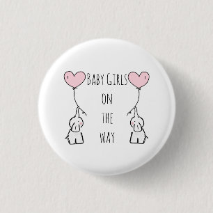 Babydoppelmädchen, die Abzeichen für Mama erwart Button