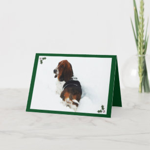 Basset en neige sur la carte de Noël avec Holly