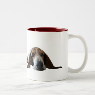 Basset Hound, das sich hinlegt Zweifarbige Tasse