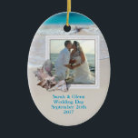 Beach Wedding Keepake Foto Ornament<br><div class="desc">Halten Sie Hochzeitsschmuck mit einem Strandthema. Fügen Sie diesem ovalen, Keramik-Ornament ein Bild hinzu und passen Sie es mit Text auf beiden Seiten an. Tropische Muscheln schmücken den Rahmen und das Hintergrundbild ist das Meer Wasser und Strand Sand. Platzieren Sie Namen, Hochzeitsdatum auf der Vorderseite und Zielort auf der Rückseite....</div>