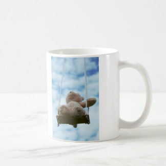 Beertje op schommel met bewolkte blauwe lucht. kaffeetasse