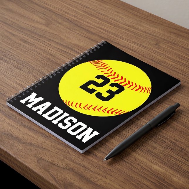 Benutzerdefiniertes Softball-Notebook Notizblock (Personalized softball notebook with custom name and number on a desk.)