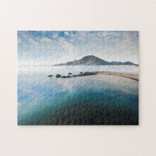 Bewölkter blauer Himmel, der im See sich