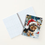 Biewer Terrier Dog Winter Wonderland Christmas Joy Notizbuch<br><div class="desc">Dieses festliche Design spiegelt den fröhlichen Geist der Urlaubssaison wider und besticht durch ein hübsches Jungtier mit einer Weihnachtsmannmütze. Der Hund ist eingebettet in ein winterliches Wunderland, mit einem Schneemann, einem dekorierten Weihnachtsbaum und wunderschön verpackten Geschenken. Schneeflocken fallen sanft ab und geben der Szene eine magische Touch, während die lebhaften...</div>