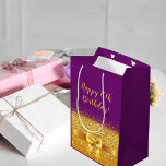 Birthday purple gold elegant mittlere geschenktüte<br><div class="desc">Elegant,  classic,  glamorous and feminine style party gift bag for a 70th birthday.  A gold colored ribbon and bow with golden glitter and sparkle,  a bit of bling and luxury for a birthday.  Violet,  purple colored background. With the text: Happy 70th Birthday!  golden letters.</div>