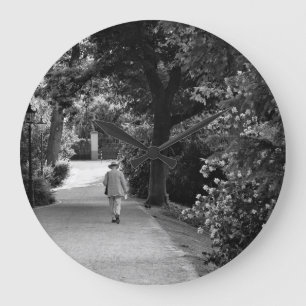 Black and white photo of old man at park große wanduhr
