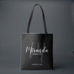 Black Modern Script Personalisiert Bridesmaiers Tasche<br><div class="desc">Fügen Sie Ihrer Hochzeit eine persönliche Touch mit personalisierten Brautmeistern Geschenktüte hinzu. Diese Tote-Tasche ist mit dem personalisierten Namen der Brautjungfrau in der modernen Schrift-Schriftart-Stil und Monogramm in hellgrauem, modernen Drehbuch-Schriftart-Stil als Hintergrund mit Titel und Hochzeit Datum in weiß, modernen serifenlosen Schriftart-Stil auf schwarzem Hintergrund. Auch perfekt für Trauzeugin, Blume...</div>