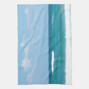 Blaue Himmels-Ozeanwellen brechen an der Küste von Küchentuch