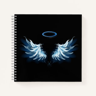 Blaue leuchtende Engelsflügel auf schwarzem Hinter Notizbuch
