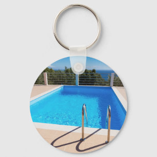 Blauer Swimmingpool mit Schritten in Meer Schlüsselanhänger