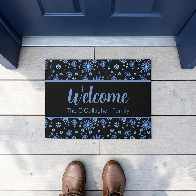 Blauer und schwarzer Blume Power Retro Fußmatte (A blue retro daisy pattern in a moody, modern aesthetic on a custom welcome mat, placed on a deck.)