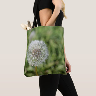 Blume aus weißem Löwenzahn auf grünem Gras Tasche