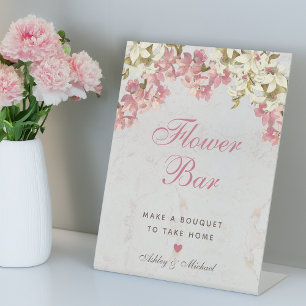 Blumenbar mit rosa Schrift und Orchideen auf Marmo Sockelschild