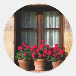 Blumenkübel am Fenster im Dorf Runder Aufkleber