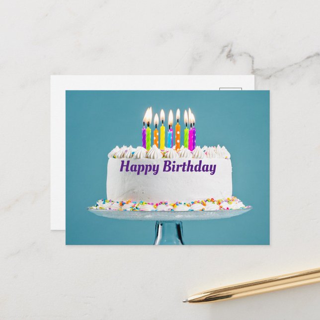 Bonne carte postale de gâteau d'anniversaire (A beautifully decorated birthday cake with colorful candles lit on top, set against a soft blue back)