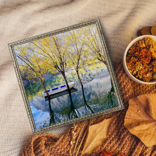 Boot zwischen zwei Bäumen auf einem See verankert Poster