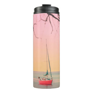 BOUTEILLES ISOTHERMES BATEAU ROUGE SUR LA PLAGE PENDANT LE COUCHER DE SO