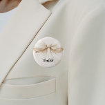 Bow-beige-Creme-Etikett Button<br><div class="desc">Beige,  cremefarbene Unterlage. Mit einem großen Bogen dekoriert. Personalisieren Sie Ihren Namen und fügen Sie ihn hinzu. Schwarzes handgeschriebenes Stilskript.</div>