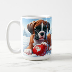 Boxer-Welpe spielt im Schnee mit einem roten Spiel Kaffeetasse