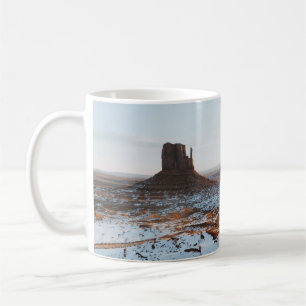 BRAUNE GESTEINSFORMATION AUF WEIßEM SCHNEEBEDECKTE KAFFEETASSE