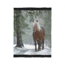 Braunes Pferd im Winterwald mit Schneefall