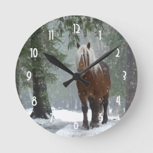 Braunes Pferd im Winterwald mit Schneefall Runde Wanduhr