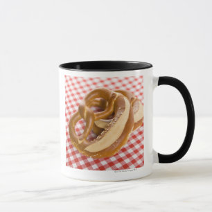 Brezel zwei auf karierter Tischdecke Tasse