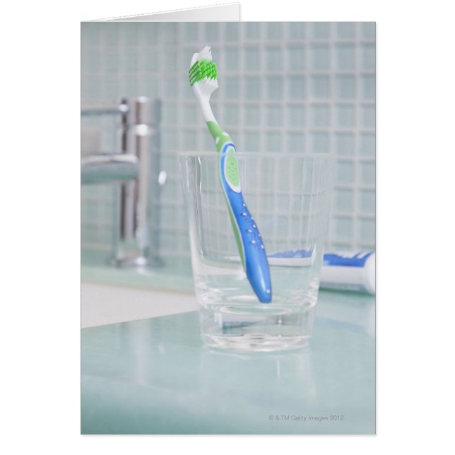 Brosse à dents dans une tasse dans la salle de bai (Devant)