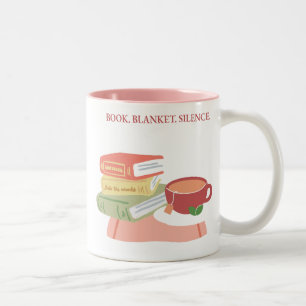 Buch. Bettdecke. Schweigen. Zweifarbige Tasse